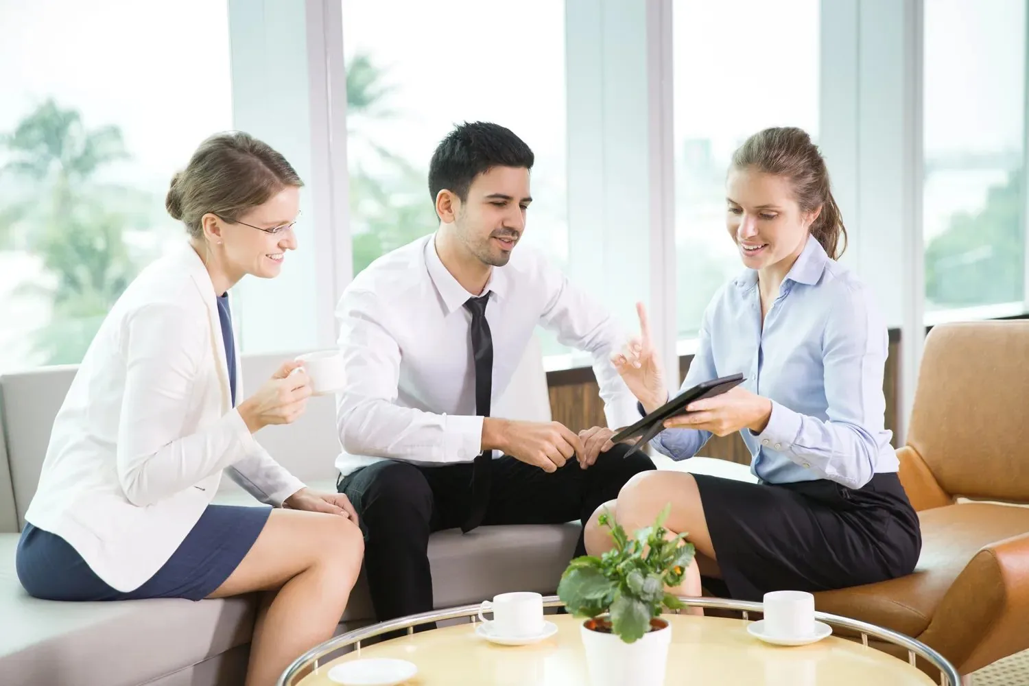 Consultants discussing a growth plan on a tablet in a bright office